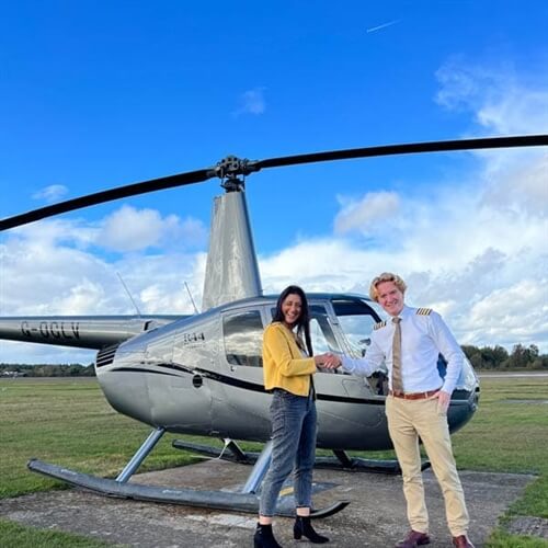 lady and man shaking hands in front of silver helicopter  lady and man shaking hands in front of silver helicopter